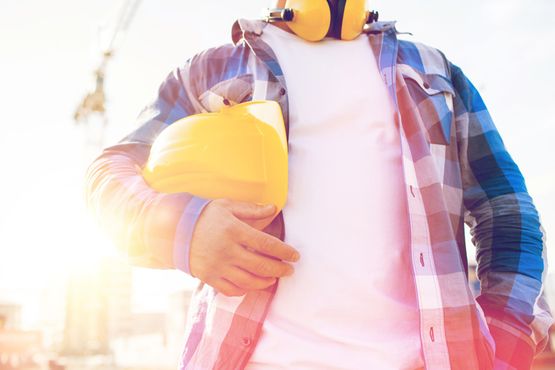 Bauarbeiter von Bauunternehmen im Burgenland klemmt seinen Helm unter den Arm